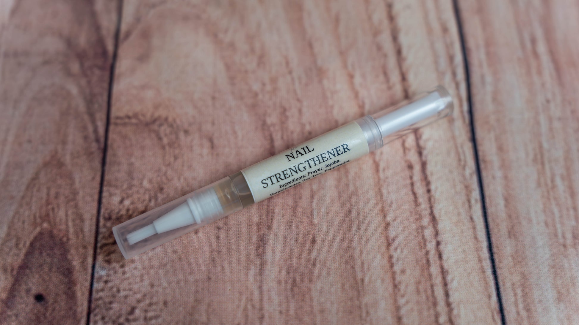 A Wright Creation Nail Strengthener Serum in a clear, eco-friendly applicator pen, infused with natural jojoba oil and plant-based ingredients to nourish and strengthen brittle nails, ideal for sensitive skin and holistic nail care.