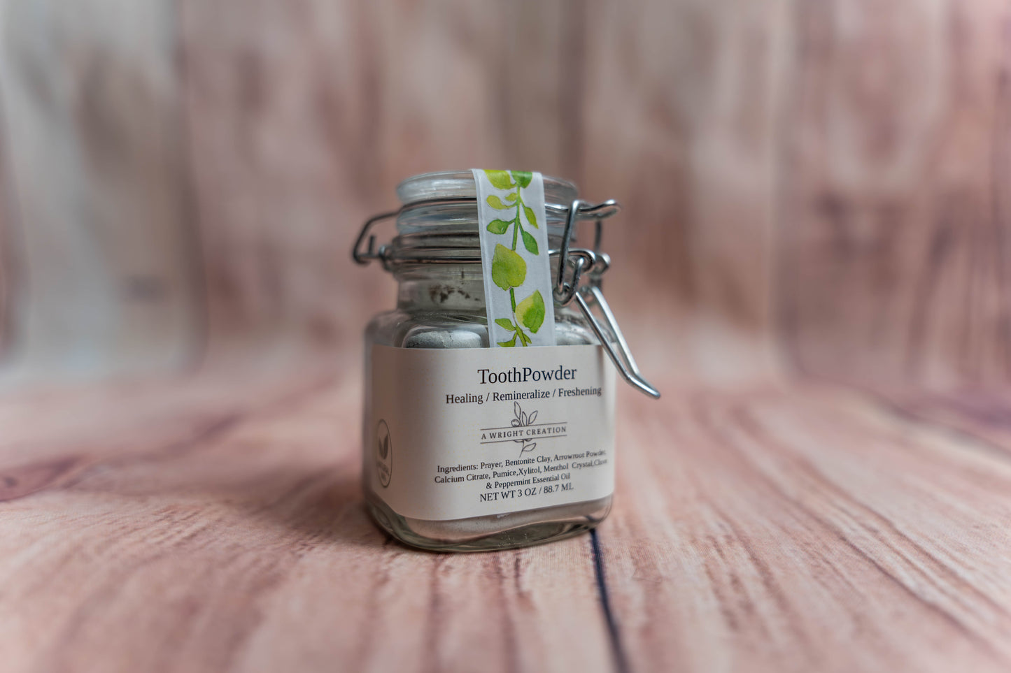 A Wright Creation Healing Tooth Powder in a reusable glass jar with eco-friendly packaging, formulated with bentonite clay, menthol crystals, and natural ingredients to heal, remineralize, and freshen teeth, ideal for sensitive oral care routines.