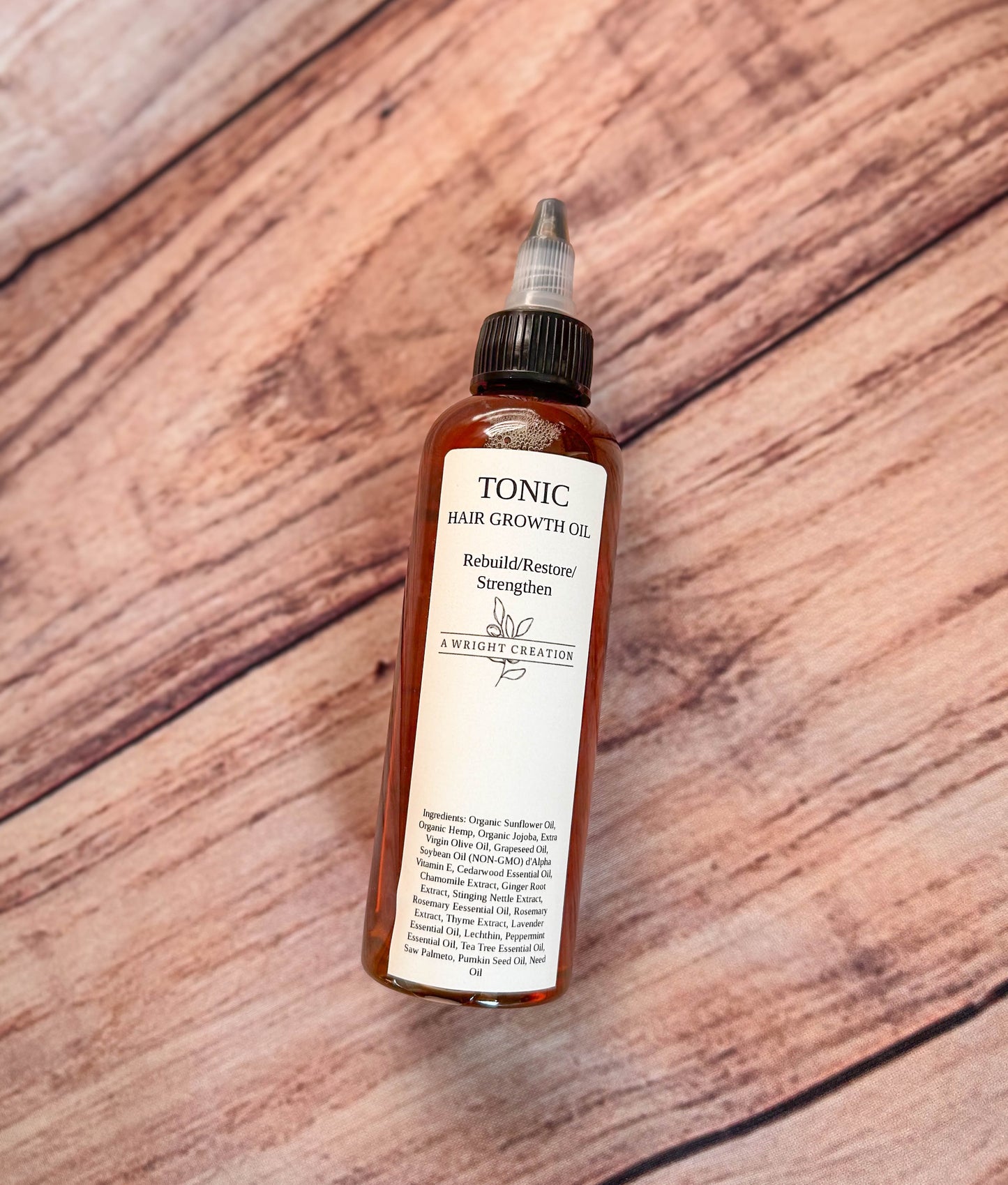A Wright Creation Tonic Hair Growth Oil in eco-friendly amber glass packaging, formulated with organic oils and natural extracts to rebuild, restore, and strengthen hair, ideal for sensitive scalps and dry, damaged hair.